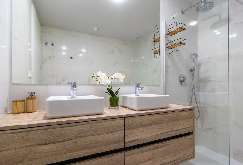 Baño doble lavabo con madera y ducha en Zaragoza